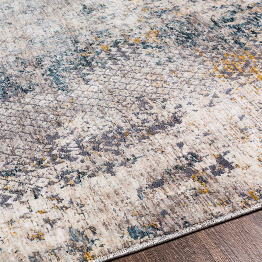 Close up of the Odell Abstract Luxe Fringe Rug, featuring dark blue, light blue, gray, and mustard colors. Texture