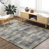 Living room scene with gray Ohtli Mosaic Luxe rug, wood floors, media cabinet, chair, and plant. Modern, neutral decor. Roomscene-Rectangle
