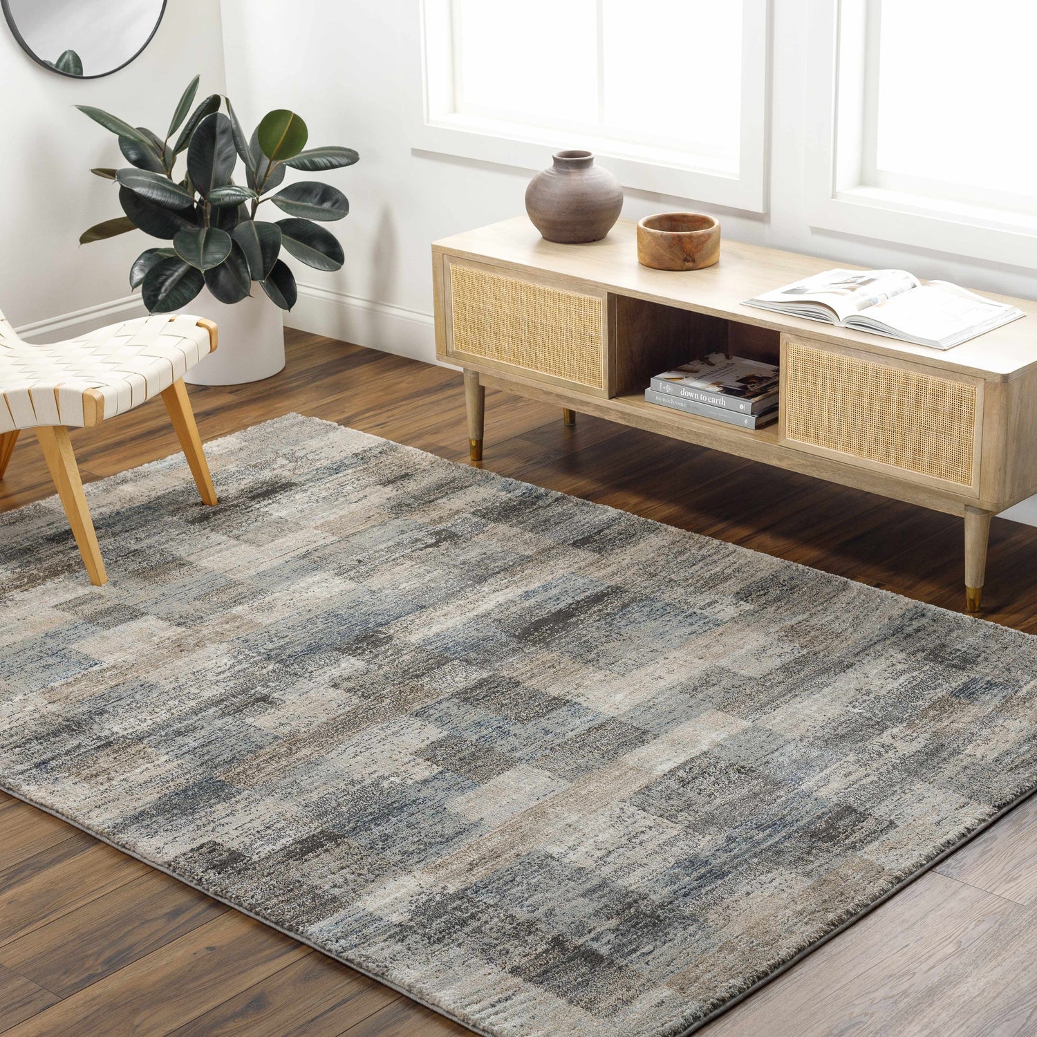 Living room scene with gray Ohtli Mosaic Luxe rug, wood floors, media cabinet, chair, and plant. Modern, neutral decor. Roomscene-Rectangle