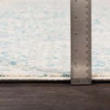 Close-up of the Omega Area Rug showing the pile height, light beige color, and teal pattern details. Pile