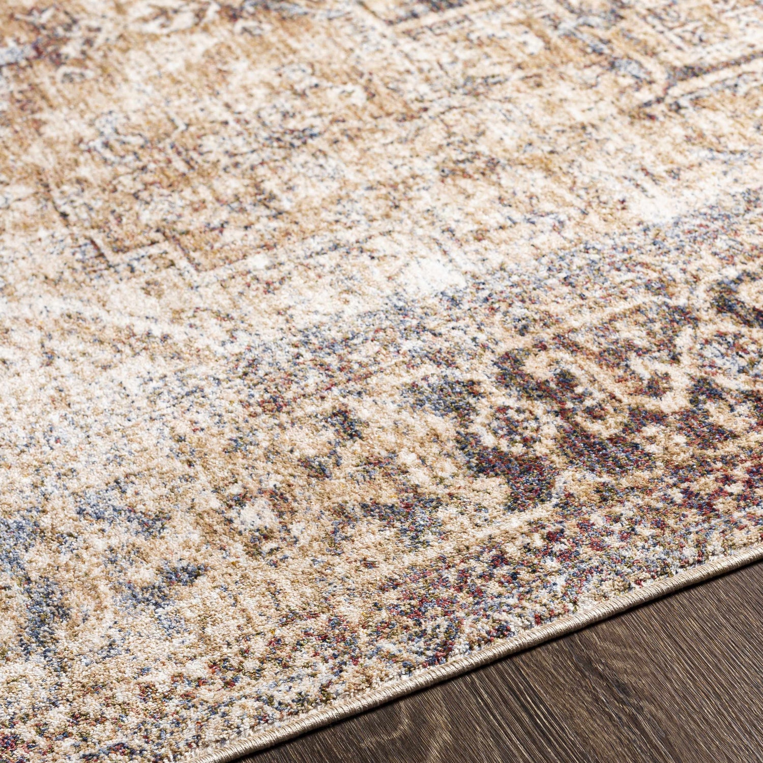 Close-up of the Onley Area Rug showing its beige, gold, and blue traditional pattern and soft texture. Texture