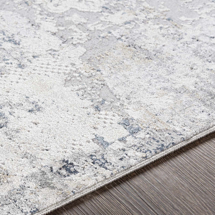 Close-up of the Ooralea Area Rug, showcasing its charcoal, light beige, and dark blue contemporary pattern and soft texture. Texture