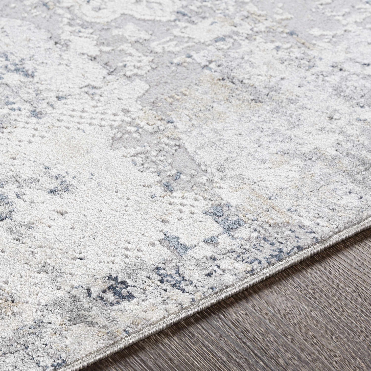 Close-up of the Ooralea Area Rug, showcasing its charcoal, light beige, and dark blue contemporary pattern and soft texture. Texture