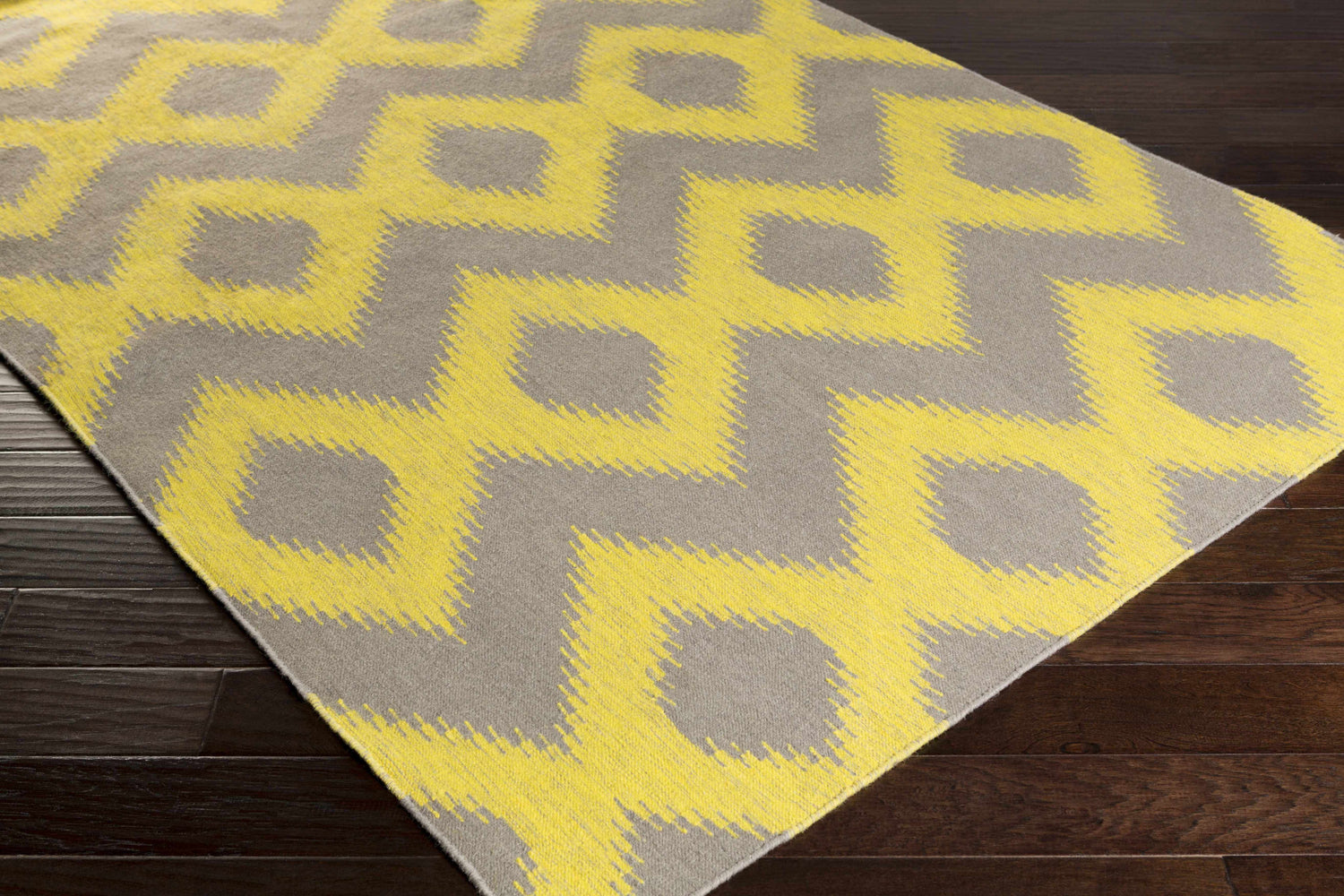 Close-up of Oradell Yellow Ikat Wool Rug showing the yellow and brown bohemian pattern and hand woven texture. Corner