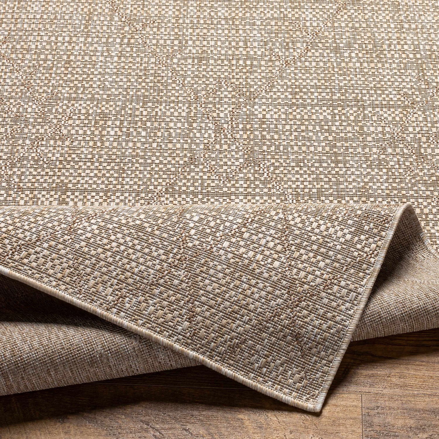 Close-up of the woven texture and backing of the Marwood Brown Nordic Rug. Neutral tones, durable polypropylene material. Fold
