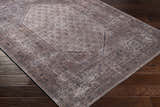 Close-up of the Tan Ormstown Distressed Washable Area Rug, featuring a traditional oriental pattern in tan, cream, and dark blue. Corner