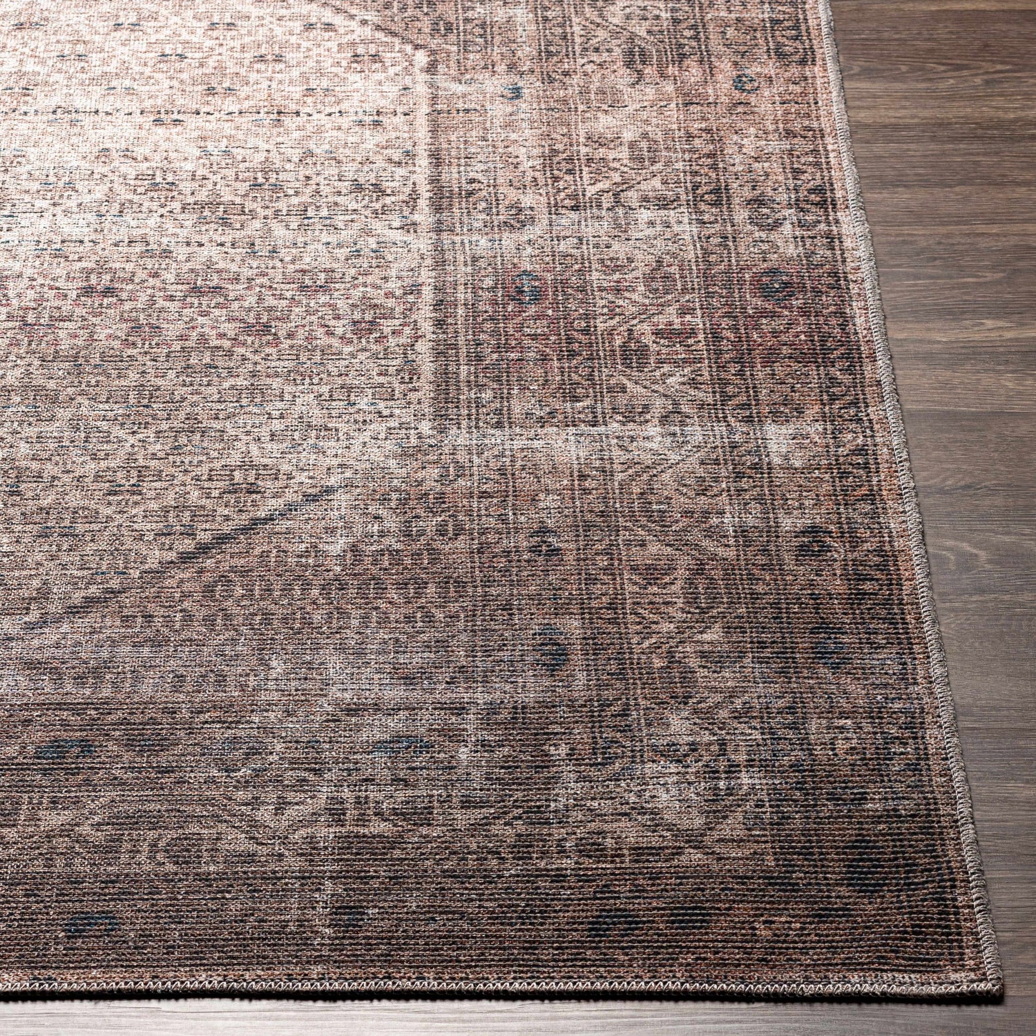 Close-up of the Tan Ormstown Distressed Washable Area Rug showing its tan, dark red, and blue oriental pattern and texture. Front