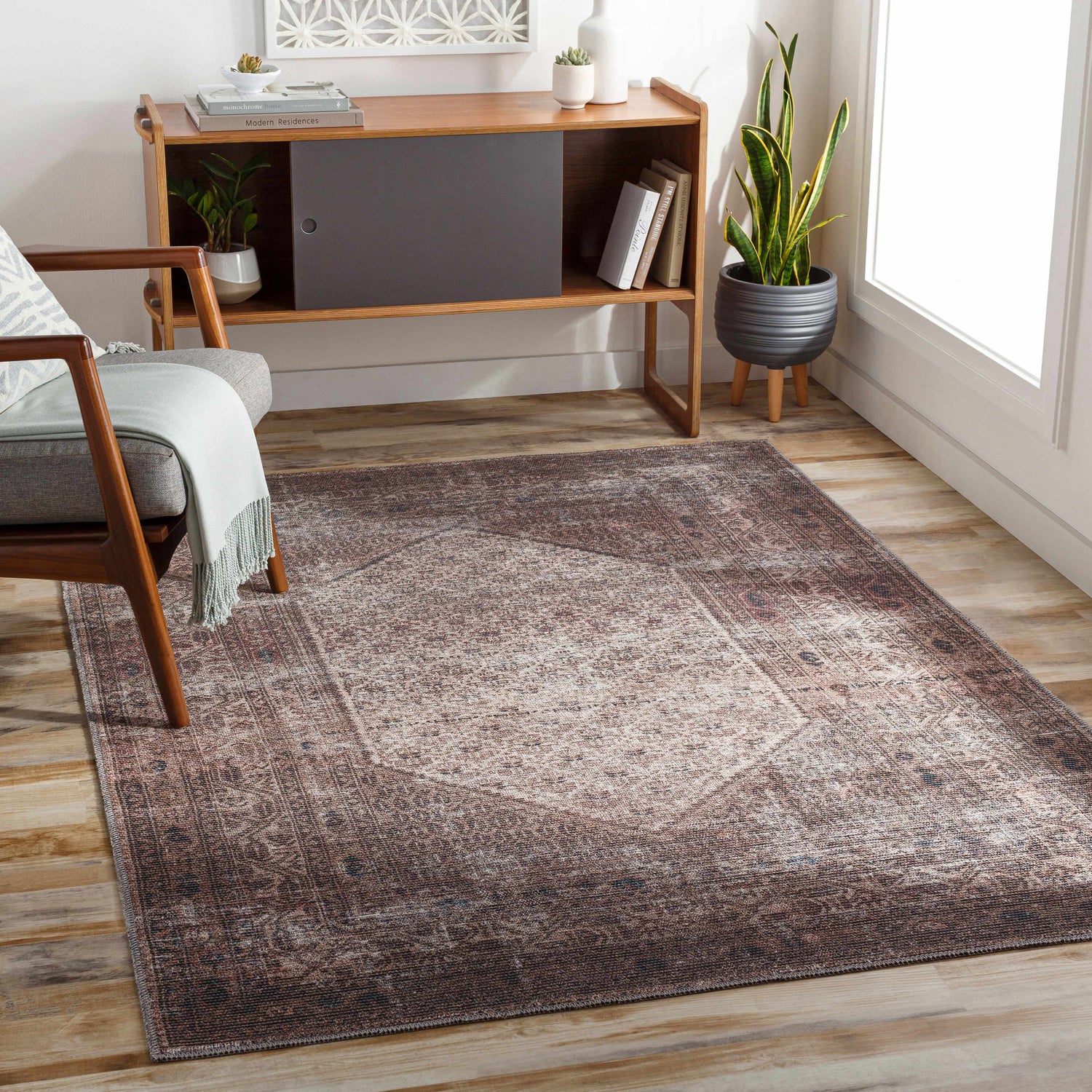 Living room scene with a Tan Ormstown Distressed Washable Area Rug, wood floors, mid-century chair, and cabinet. Roomscene-Rectangle