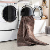 Tan Ormstown Distressed Washable Area Rug in a laundry room, fresh from the dryer. Easy care rug. Washing-Machine