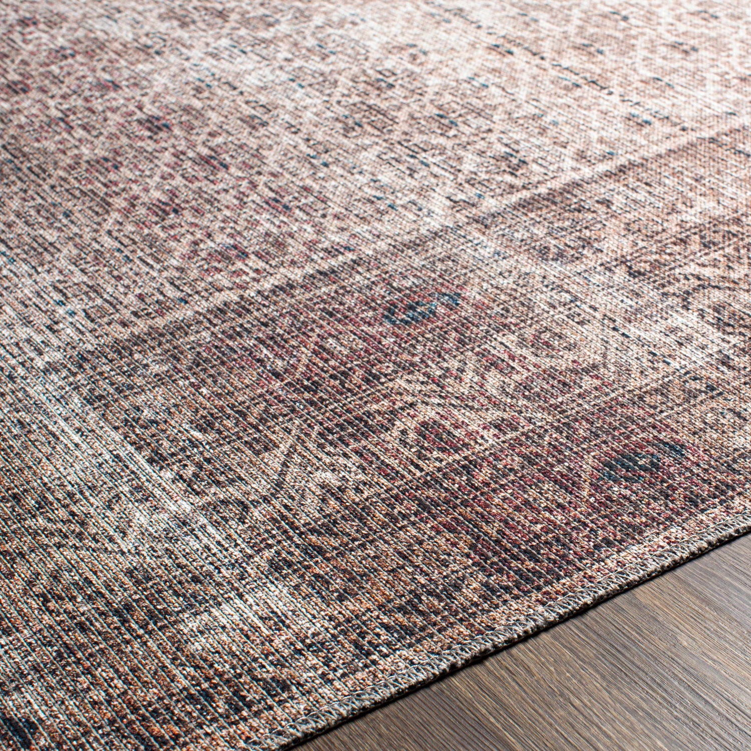 Close-up of the Tan Ormstown Distressed Washable Area Rug showing its cream, red, and blue oriental pattern and distressed texture. Texture