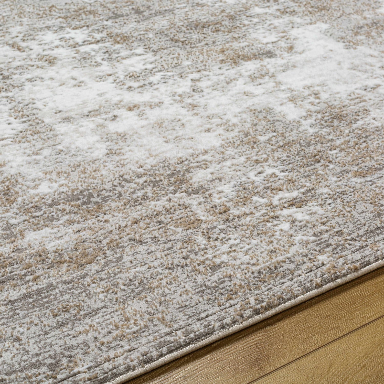 Close-up of the Oshawa Area Rug. Contemporary style with driftwood, gray, ivory, and tan colors. Machine woven texture. Texture