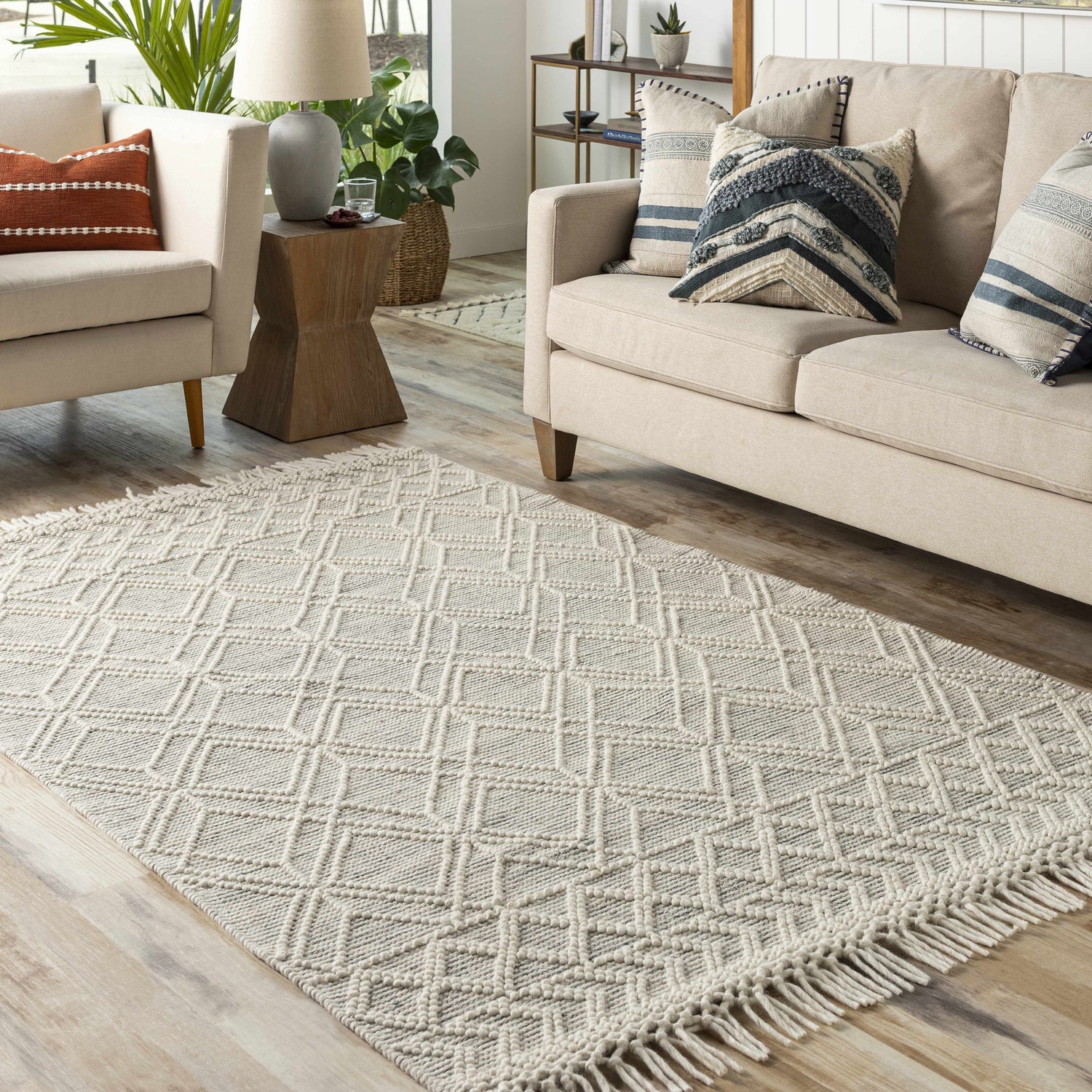 Living room scene with a cream sofa and the neutral Ossun Wool Rug with Tassels, showcasing a farmhouse style. Roomscene-Rectangle