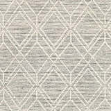 Close-up of the Ossun Wool Rug. Cream geometric pattern on a neutral and black, hand-woven rug with a textured look. Swatch