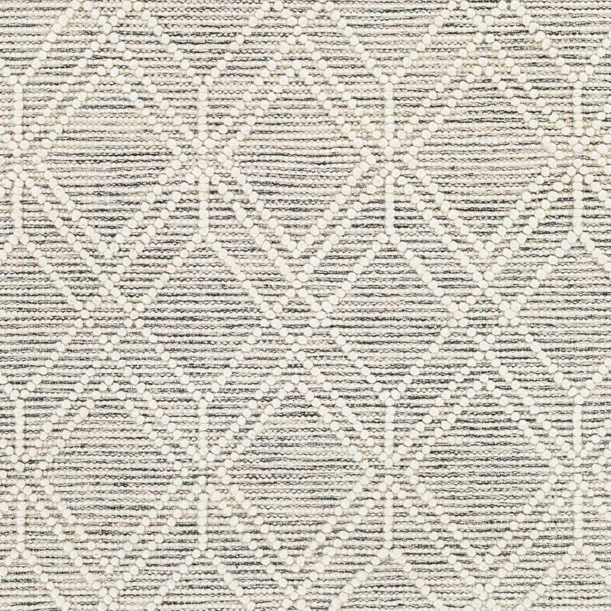 Close-up of the Ossun Wool Rug. Cream geometric pattern on a neutral and black, hand-woven rug with a textured look. Swatch