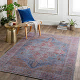 Living room scene with the Otaki Washable Area Rug in dark gray, purple, and brown, styled with a chair, side table, and plants. Roomscene-Rectangle