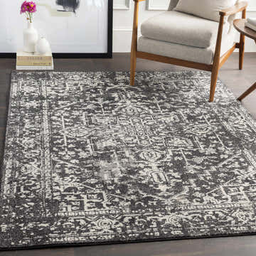 Living room scene with a Rachel Black Area Rug, gray chair, and dark wood floors. Roomscene-Rectangle