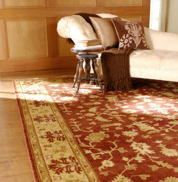 Traditional living room scene with a brick red Parkhill Area Rug, beige chaise lounge, and wooden accents. Roomscene-Rectangle