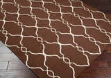 Close-up of Partington Brown Wool Carpet Area Rug featuring a geometric trellis pattern in beige on a dark brown background. Corner
