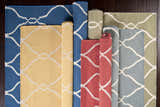 Variety of Partington wool rugs in blue, yellow, red, gray, and green with a geometric trellis pattern. Styleshot