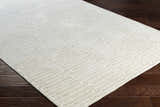 Close-up of the hand-knotted Partlow Area Rug. Beige and cream viscose rug with a contemporary geometric pattern. Corner