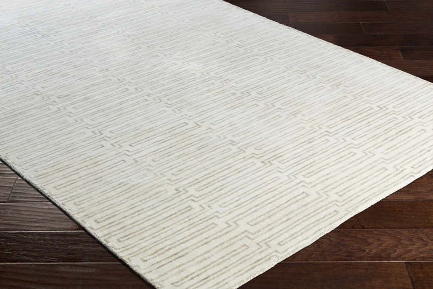 Close-up of the hand-knotted Partlow Area Rug. Beige and cream viscose rug with a contemporary geometric pattern. Corner