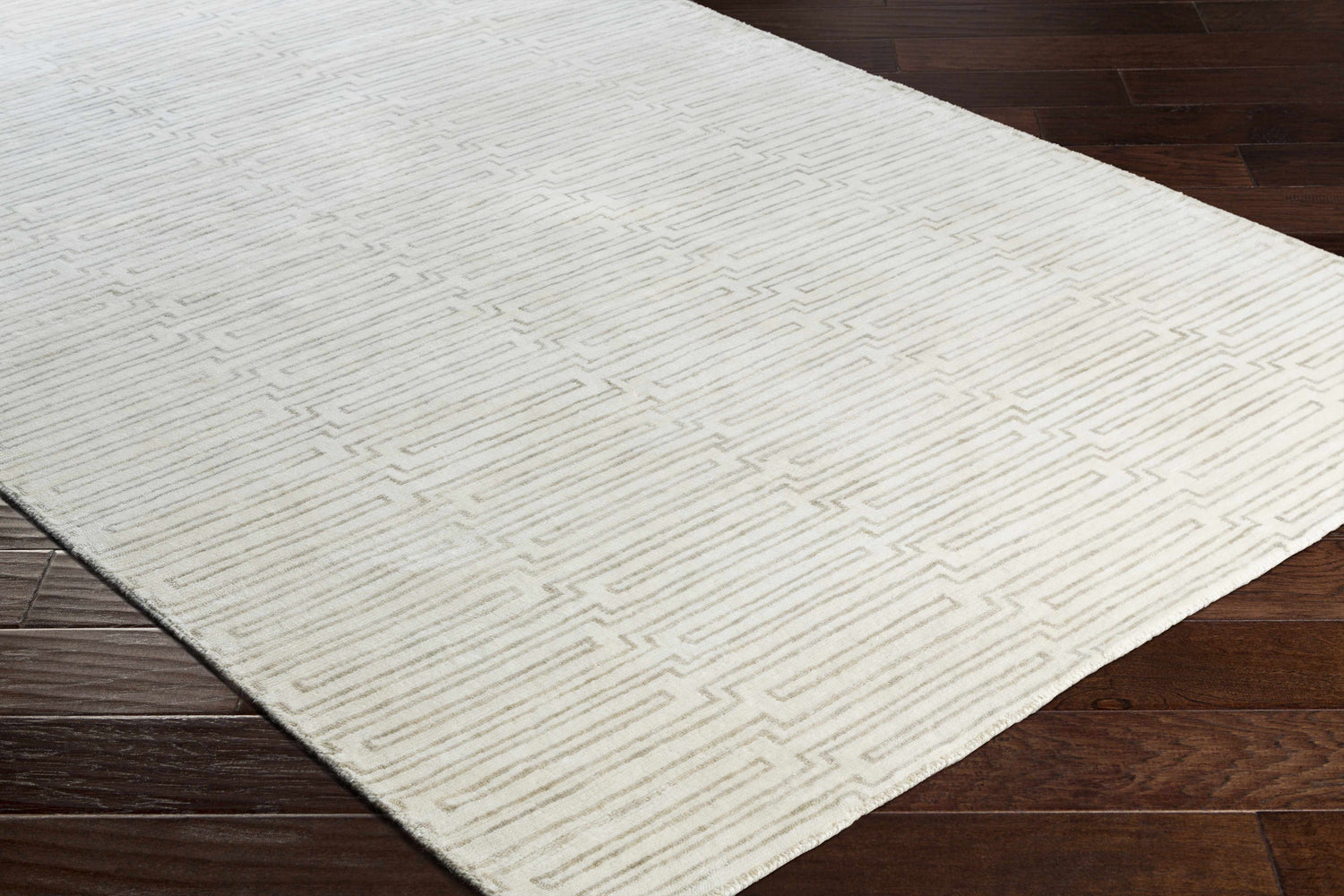 Close-up of the hand-knotted Partlow Area Rug. Beige and cream viscose rug with a contemporary geometric pattern. Corner
