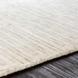 Close-up of the hand-knotted Partlow Area Rug. Beige and cream viscose with a subtle, contemporary geometric pattern. Texture