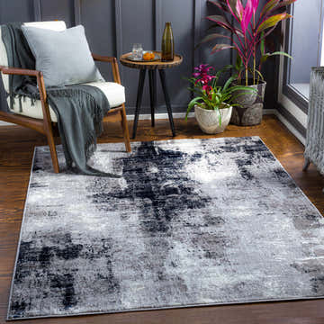 Living room scene with a gray and white Passi Area Rug, modern chair, side table, and plants. Roomscene-Rectangle