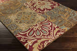 Close-up of the Pattersonville Area Rug featuring a patchwork of floral and geometric patterns in burgundy, brown, and tan. Corner