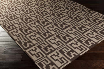 Close-up of Paxville Area Rug. Beige and dark red wool rug with a geometric, Greek key-inspired pattern. Hand woven texture. Corner