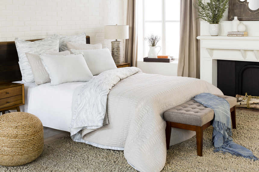 Bedroom scene with a cream Oakridge Area Rug, white bedding, and a cozy, neutral color palette. Roomscene-Rectangle