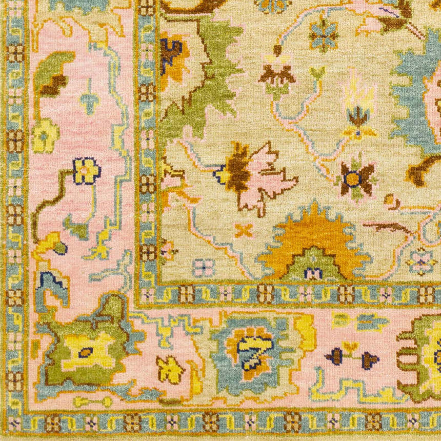 Close-up of the hand-knotted Peacham Area Rug. Bohemian design in brown, dusty pink, mustard, and sky blue wool. Swatch