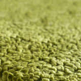 Close-up of the Frederika Solid Olive Green Wool Shag Rug showing its thick, textured wool fibers. Texture