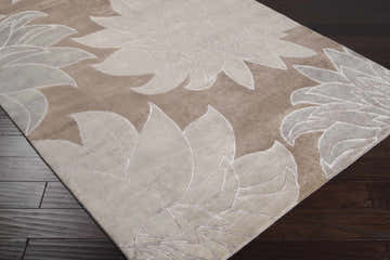 Close-up of the Penalosa Area Carpet. Hand-knotted wool rug with a large floral pattern in camel, beige, and white tonal colors. Corner