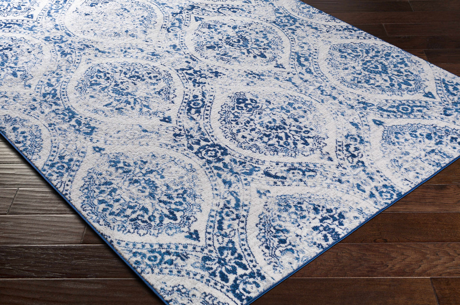 Close-up of the Penrhyndeudraeth Area Rug showcasing its blue and off-white traditional medallion pattern. Corner