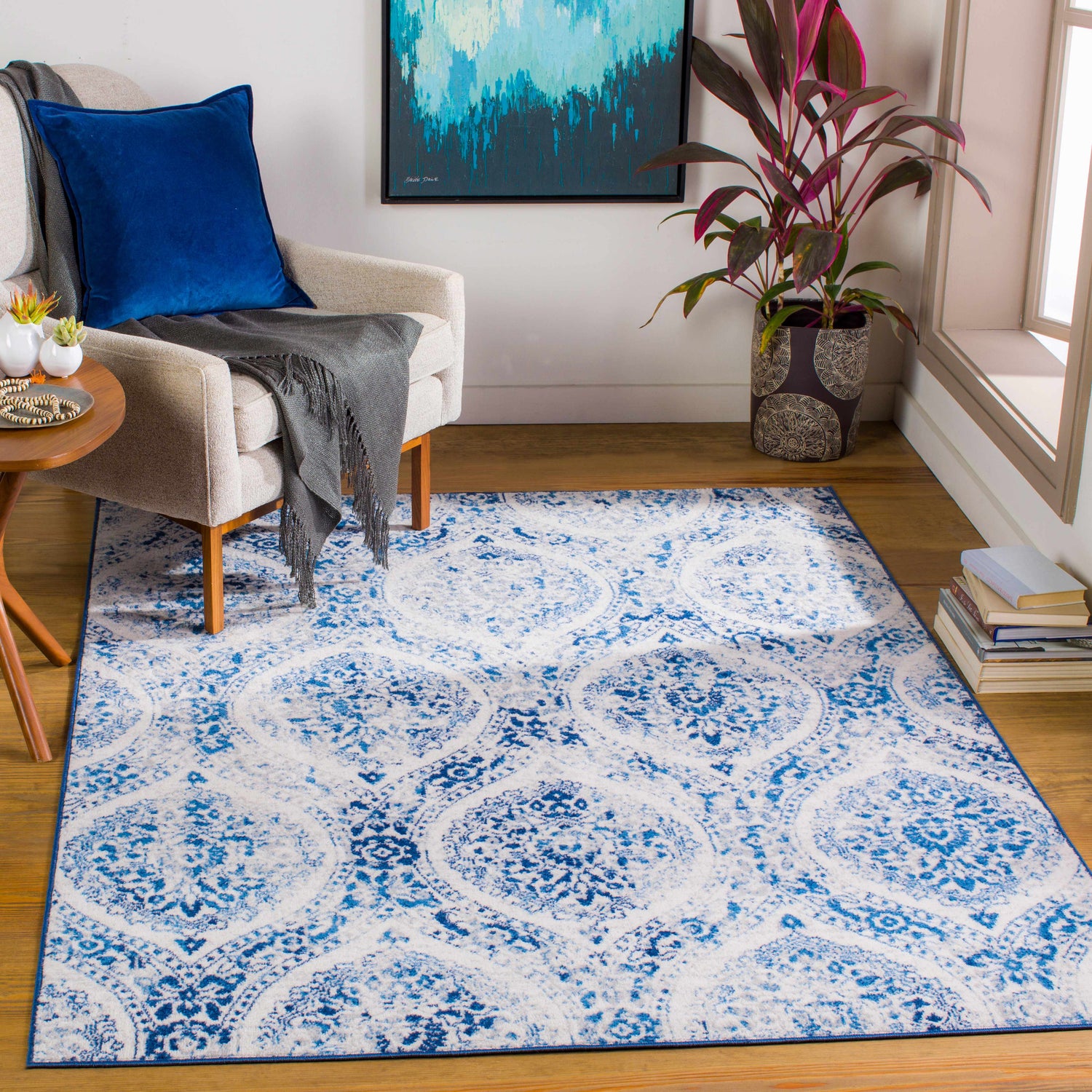 Living room scene with blue and off white Penrhyndeudraeth Area Rug, armchair, and wood floors. Roomscene-Rectangle