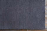 Close-up of the dark blue Philipsburg Carpet showing its hand-knotted texture and wool-viscose blend on wood floor. Corner