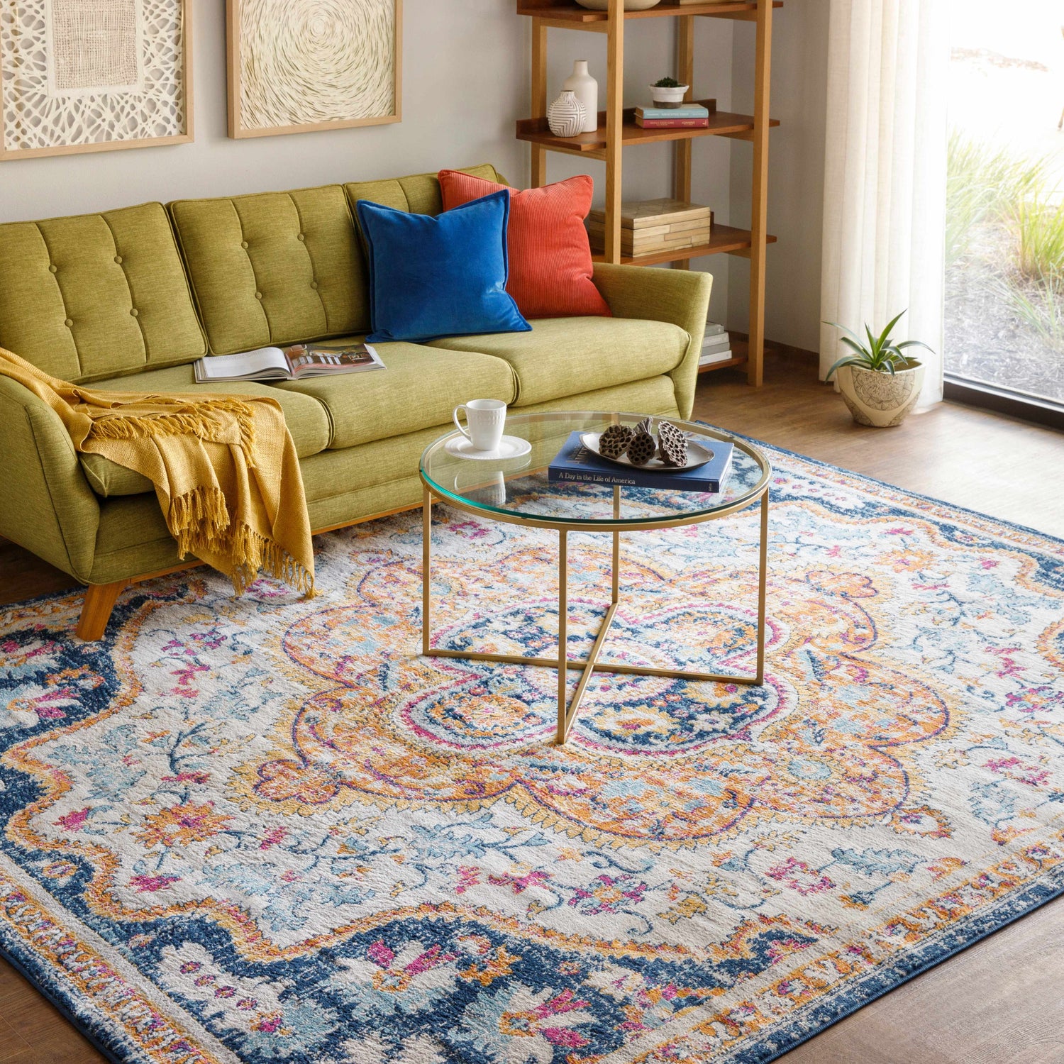 Living room scene with a Pimperne Traditional Medallion Area Rug in burnt orange, fuchsia, and navy under a glass coffee table. Roomscene-Rectangle