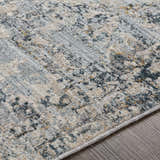 Close up of the Pinjarra Luxe Rug showing its charcoal, cream, gray, and blue contemporary pattern and soft polyester texture. Texture