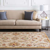 Living room scene with a floral Pirtleville Area Rug, beige sofa, gray pillows, and a marble side table. Roomscene-Rectangle