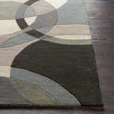 Close-up of the Rilton Gray Wool Carpet showing its geometric pattern, gray, black, taupe, and teal colors, and wool texture. Front