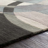 Close-up of the hand-tufted Rilton Gray Wool Carpet. Features a contemporary geometric design in gray, charcoal, and taupe tones. Texture