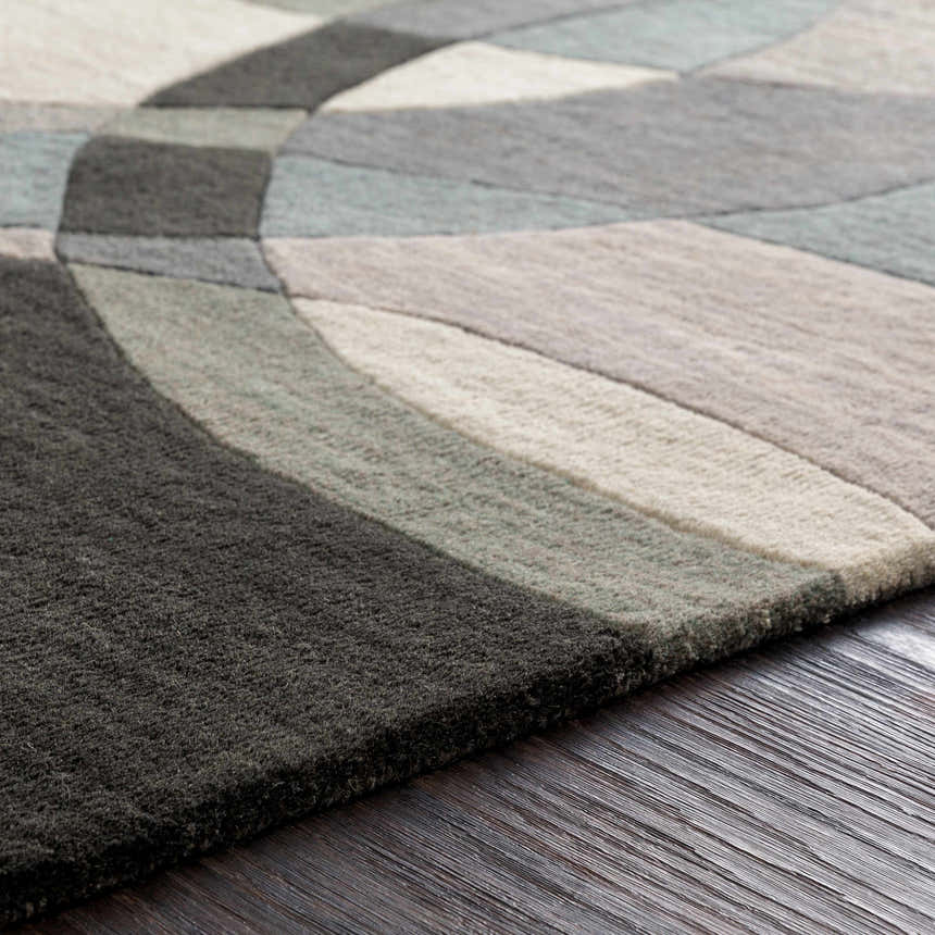 Close-up of the hand-tufted Rilton Gray Wool Carpet. Features a contemporary geometric design in gray, charcoal, and taupe tones. Texture