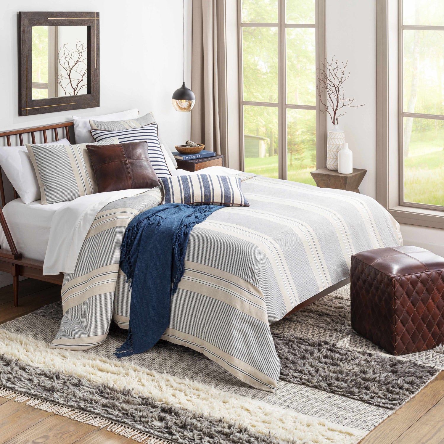 Bedroom scene with Elizabeth Area Rug layered under a bed and leather ottoman. Neutral tones, farmhouse style. Styleshot