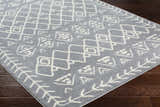 Close-up of the Plumsteadville Area Rug in cream and slate, featuring a geometric farmhouse pattern on dark wood floors. Corner