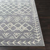 Close up of the Plumsteadville Area Rug in cream and slate, with a geometric pattern on dark wood flooring. Front