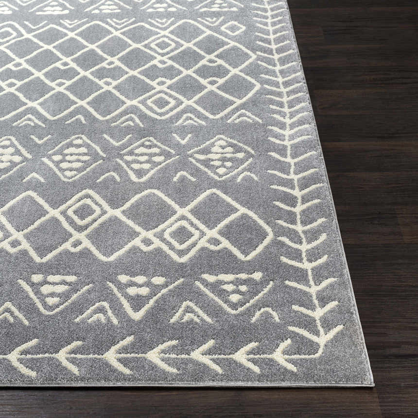 Close up of the Plumsteadville Area Rug in cream and slate, with a geometric pattern on dark wood flooring. Front