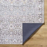 Close-up of the Rainier Damask Brown Washable Rug showing the traditional pattern, dark brown and red colors, and non-slip backing. Fold
