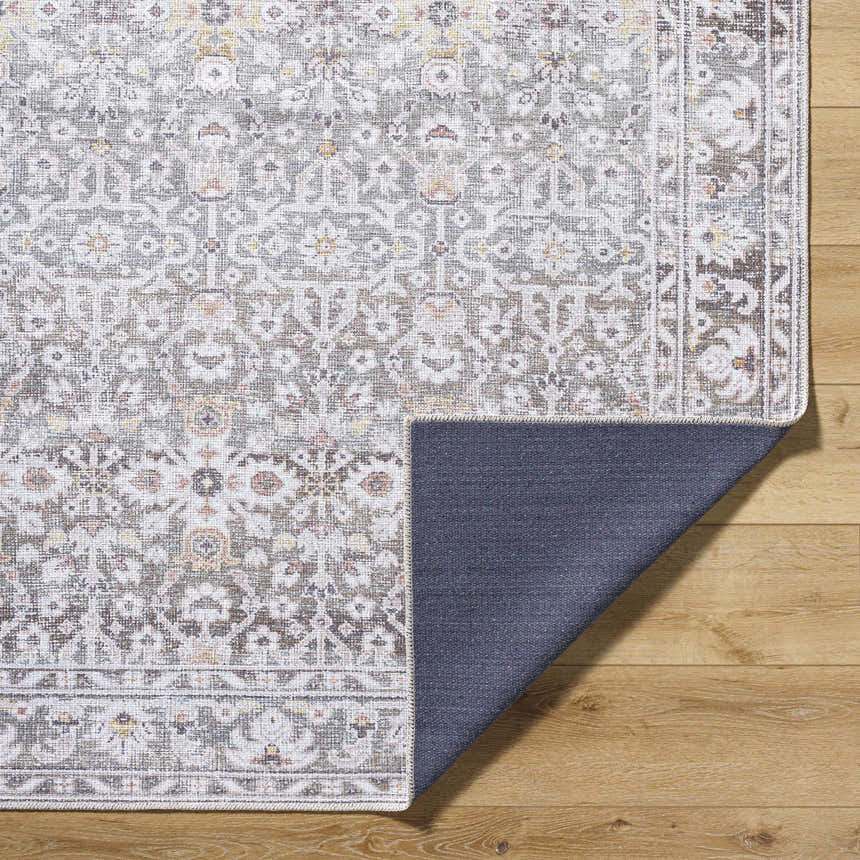 Close-up of the Rainier Damask Brown Washable Rug showing the traditional pattern, dark brown and red colors, and non-slip backing. Fold