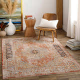 Living room scene with a brick red Polomolok Luxe Performance Rug, wood chair, side table, and neutral decor. Roomscene-Rectangle